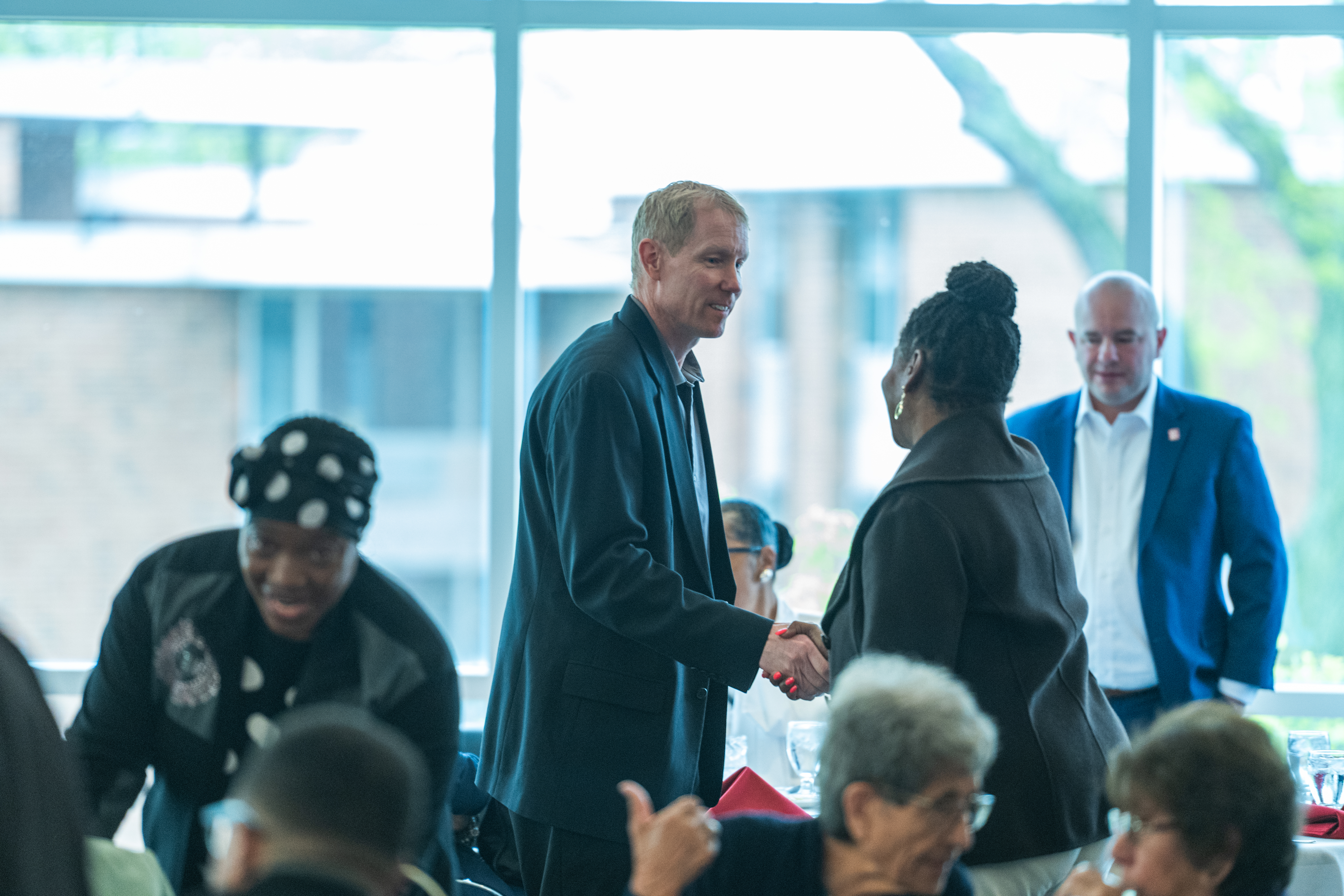 guests shaking hands at the external diversity council luncheon